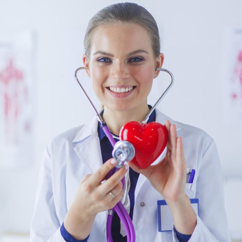 doctor-with-stethoscope-examining-red-heart-isolated-white-background