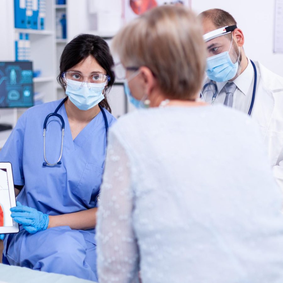 senior-woman-suffering-arrhytmias-talking-with-cardiologist-during-examination-hospital-wearing-face-mask-against-coronavirus